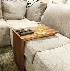 a coffee table with a remote control on it in front of a couch and ottoman
