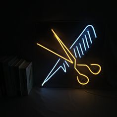 a neon sign with scissors on it in the dark