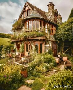 a house with lots of plants and flowers around it