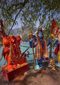 statues of hindu deities in front of the water