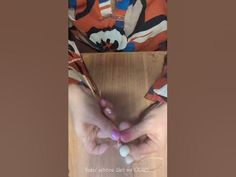 two hands holding beads on top of a wooden table