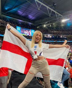 a woman holding an england flag at a sporting event