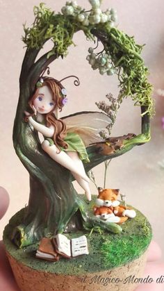 a fairy figurine sitting on top of a tree