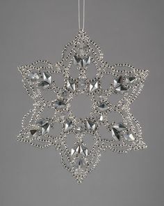a silver snowflake ornament hanging from a string