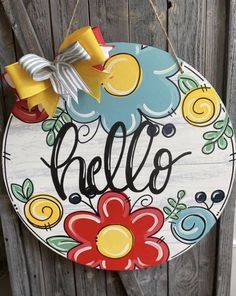 a sign that says hello painted on the side of a wooden fence with flowers and leaves