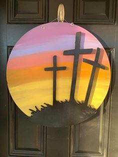 a door hanger with three crosses painted on it