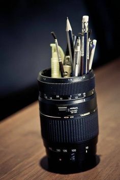 a camera lens filled with pens and pencils