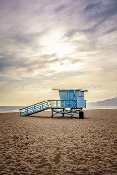 a lifeguard tower on the beach with stairs leading to it