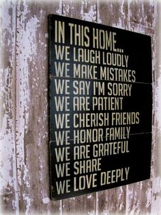 a wooden sign that says in this home we laugh