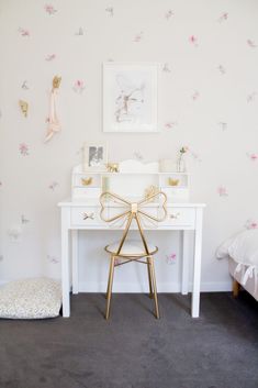 a white desk and chair in a room with floral wallpaper on the walls behind it