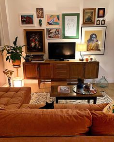 a living room filled with furniture and pictures on the wall above it's coffee table
