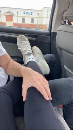 a person sitting in the back seat of a car with their feet on the floor