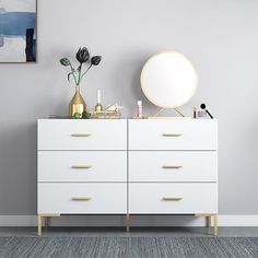there is a white dresser with gold handles