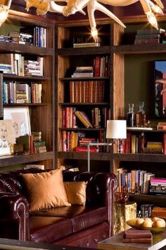 a living room with a pool table, couch and bookcases filled with books