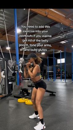 a woman doing squats in a gym with an exercise quote on the wall behind her