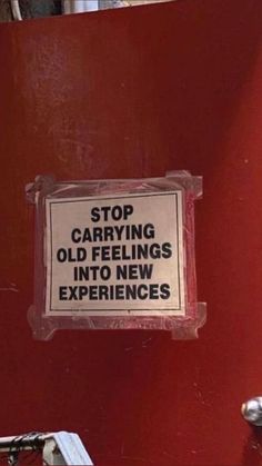a sign that is on the side of a red wall saying stop carrying old feelings into new experiences