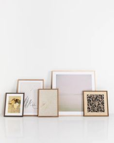 four framed pictures on a white wall next to each other