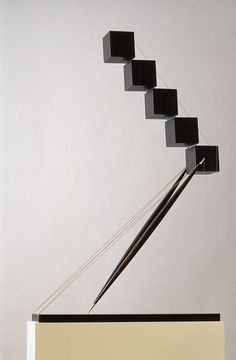 a black and white sculpture with four cubes on it
