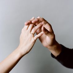 two people holding hands with their fingers together