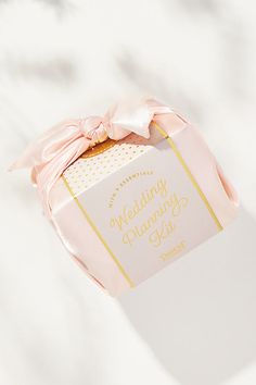 a wedding planning kit sitting on top of a white countertop next to a pink ribbon
