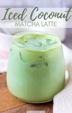a close up of a drink in a glass on a wooden table with the words iced coconut matcha latte