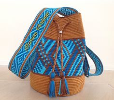 a blue and brown woven bag with tassels