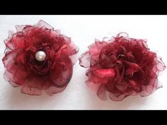 two red flowers with pearls on them sitting next to each other in front of a white background