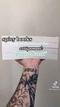 a person holding up a book with the words spicy books on it and an image of flowers