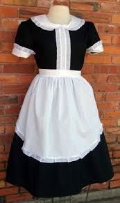 a black and white dress on a mannequin stand next to a brick wall