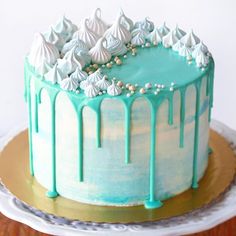 a cake with green icing and white frosting on top sitting on a plate