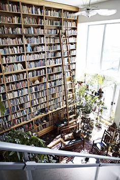 a room filled with lots of books next to a window