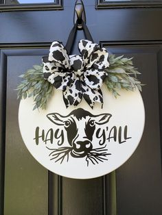 a door hanger with a cow's head and the words happy y'all on it