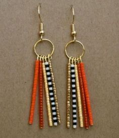 two pairs of orange, black and white beaded earrings with gold hoops on them