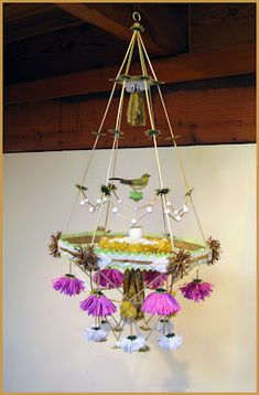 a chandelier hanging from the ceiling with purple flowers and birds on it's wings
