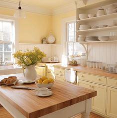 a kitchen with yellow walls and wooden counter tops, white cabinets and open shelving
