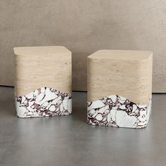 two marbled wooden blocks sitting on top of a cement floor next to each other