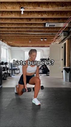 a woman in a white tank top and black shorts is doing exercises with dumbbells