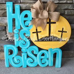 a wooden sign that says he is risen and has a bow on the front of it