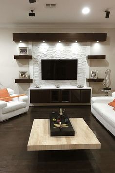 a living room with two white couches and a flat screen tv on the wall