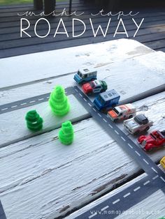 a toy road with cars on it and the words make this easy road way written in white letters