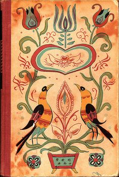 an old book with two birds sitting on it's cover, surrounded by flowers and swirls