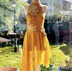 a mannequin wearing a yellow dress with flowers on it