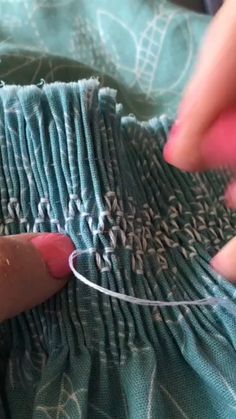 someone is stitching fabric with scissors and thread