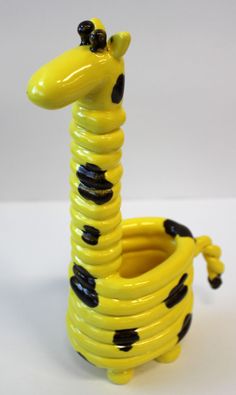 a yellow and black giraffe shaped vase sitting on top of a table