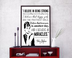 a red shelf with a black and white poster on it that says i believe in being strong