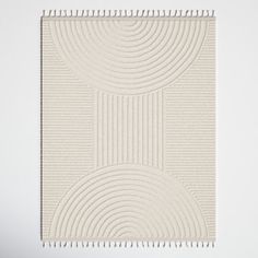 a white wall hanging on the side of a wall with an abstract design in it