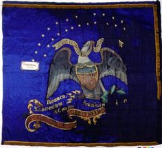 an old flag with the state seal and eagle on it's side, hanging from a wall