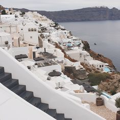 an aerial view of white buildings and the ocean in oia, paros island