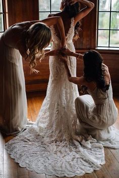 three bridesmaids helping each other get ready for their wedding at the same time