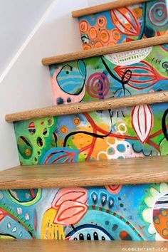 colorful painted steps leading up to the top of a stair case with flowers and leaves on it